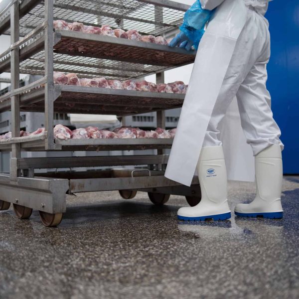 Medewerker rolt een kar met vlees weg bij de rookoven om te gaan reinigen met Ecolab Topaz HD4